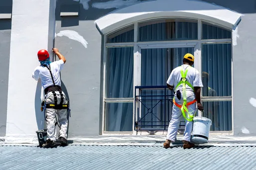 Two painters in harnesses refreshing a storefront in downtown Burbank